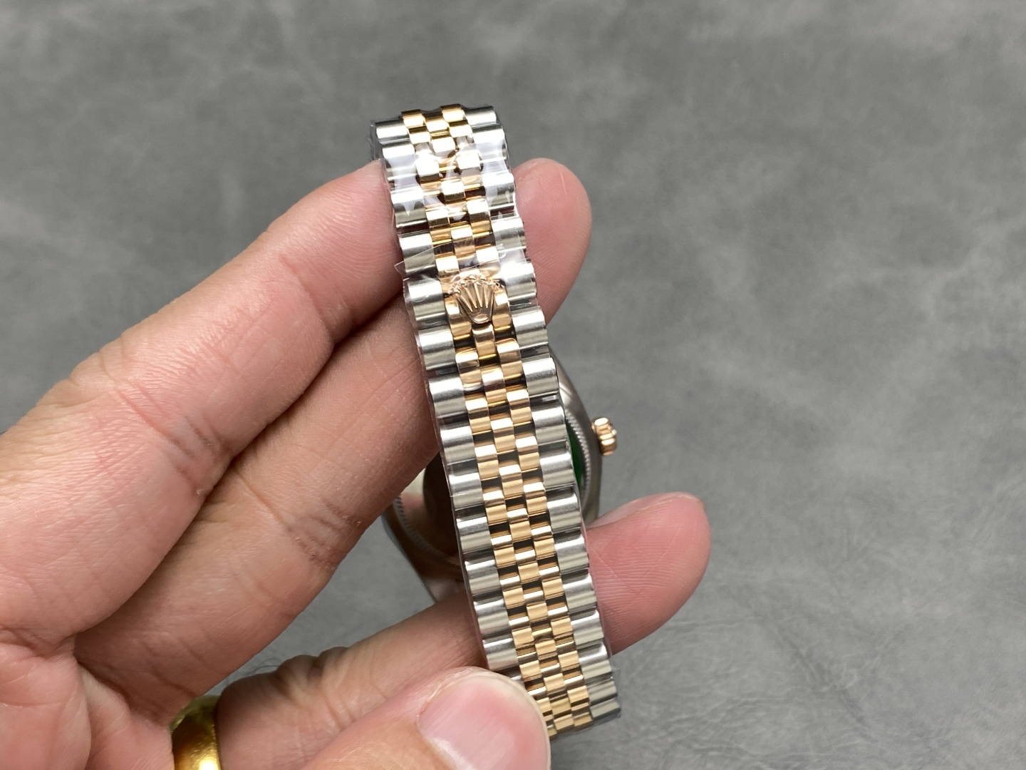 Detalle del brazalete de dos tonos y el logo grabado en el cierre de un reloj clon 1:1.