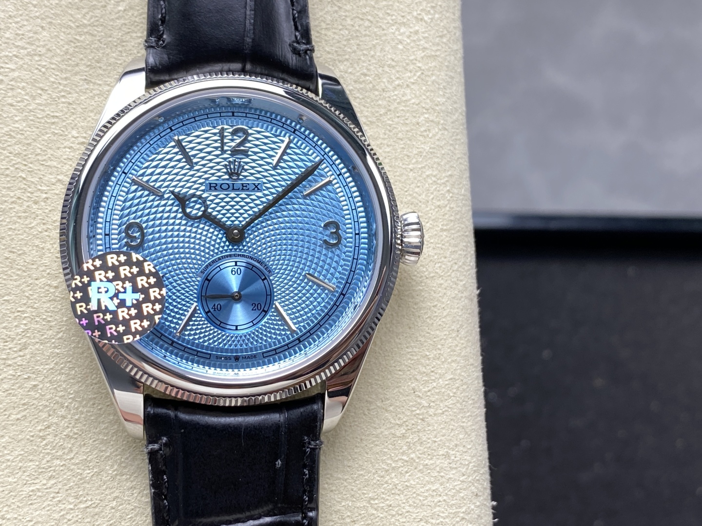 Close-up of vibrant blue guilloche dial on high quality Rolex replica showing applied markers, small subdial, and finishing details