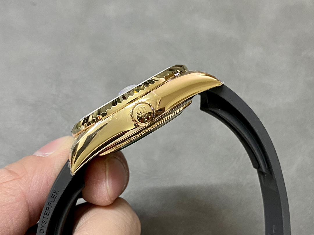 Perfil lateral de un Rolex Sky-Dweller super clon, mostrando el bisel estriado y la corona de oro amarillo.