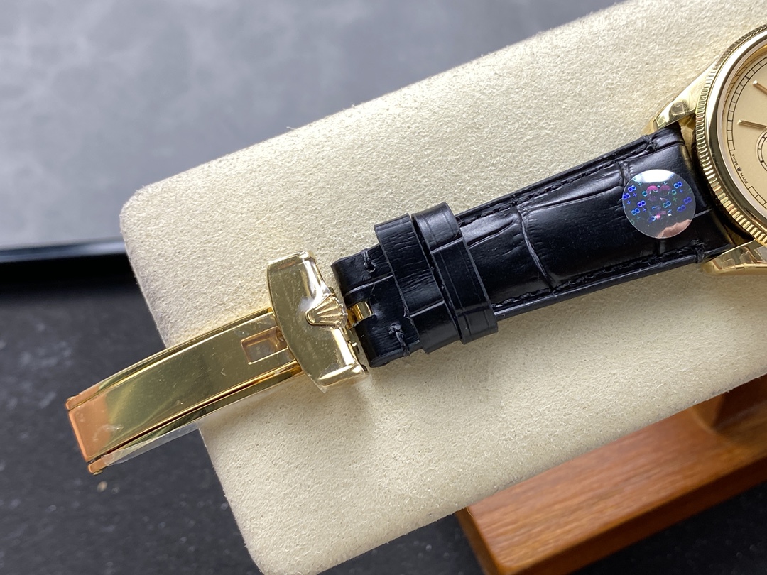 Gold deployment clasp and black crocodile-style strap with protective sticker