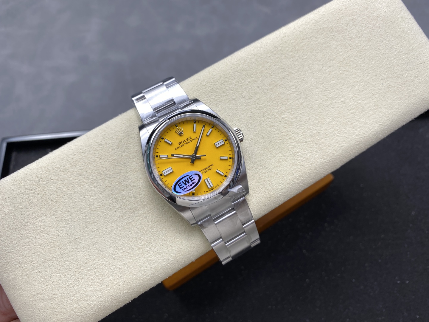 Premium replica Rolex Oyster Perpetual featuring a vibrant yellow dial and polished stainless steel case with Oyster bracelet, displayed on a watch cushion
