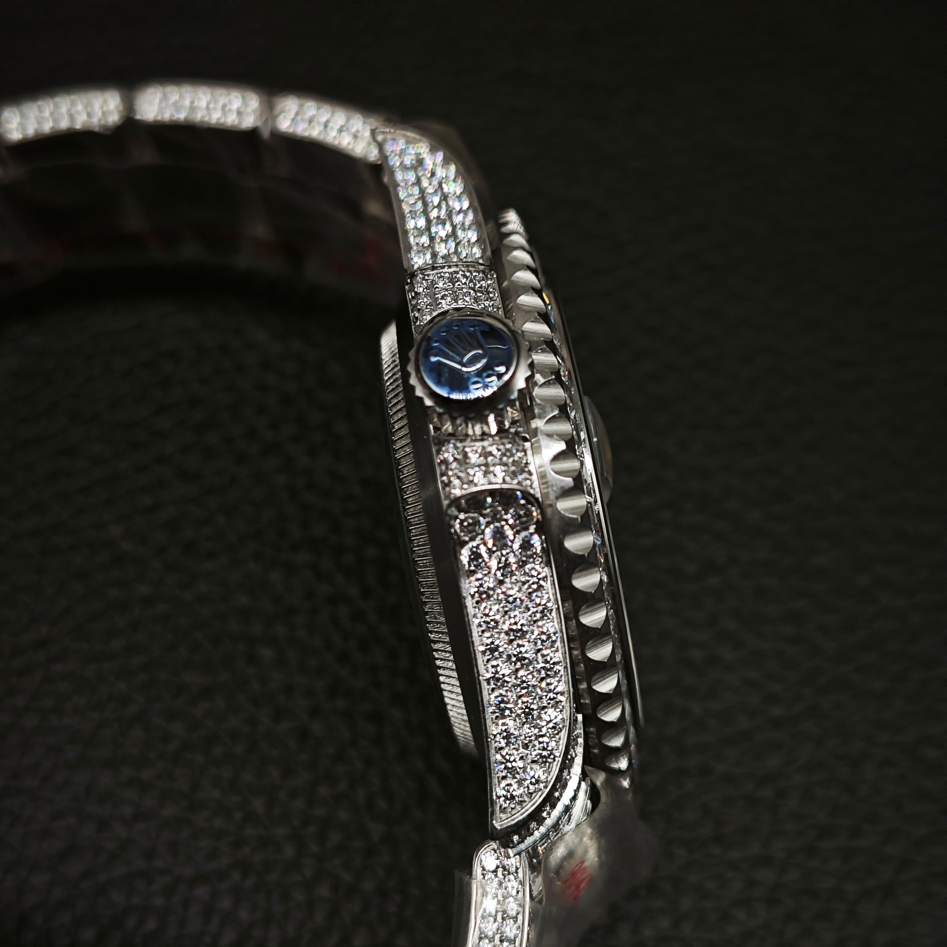 Side profile of luxury diamond Rolex Submariner replica highlighting fluted bezel and paved lugs