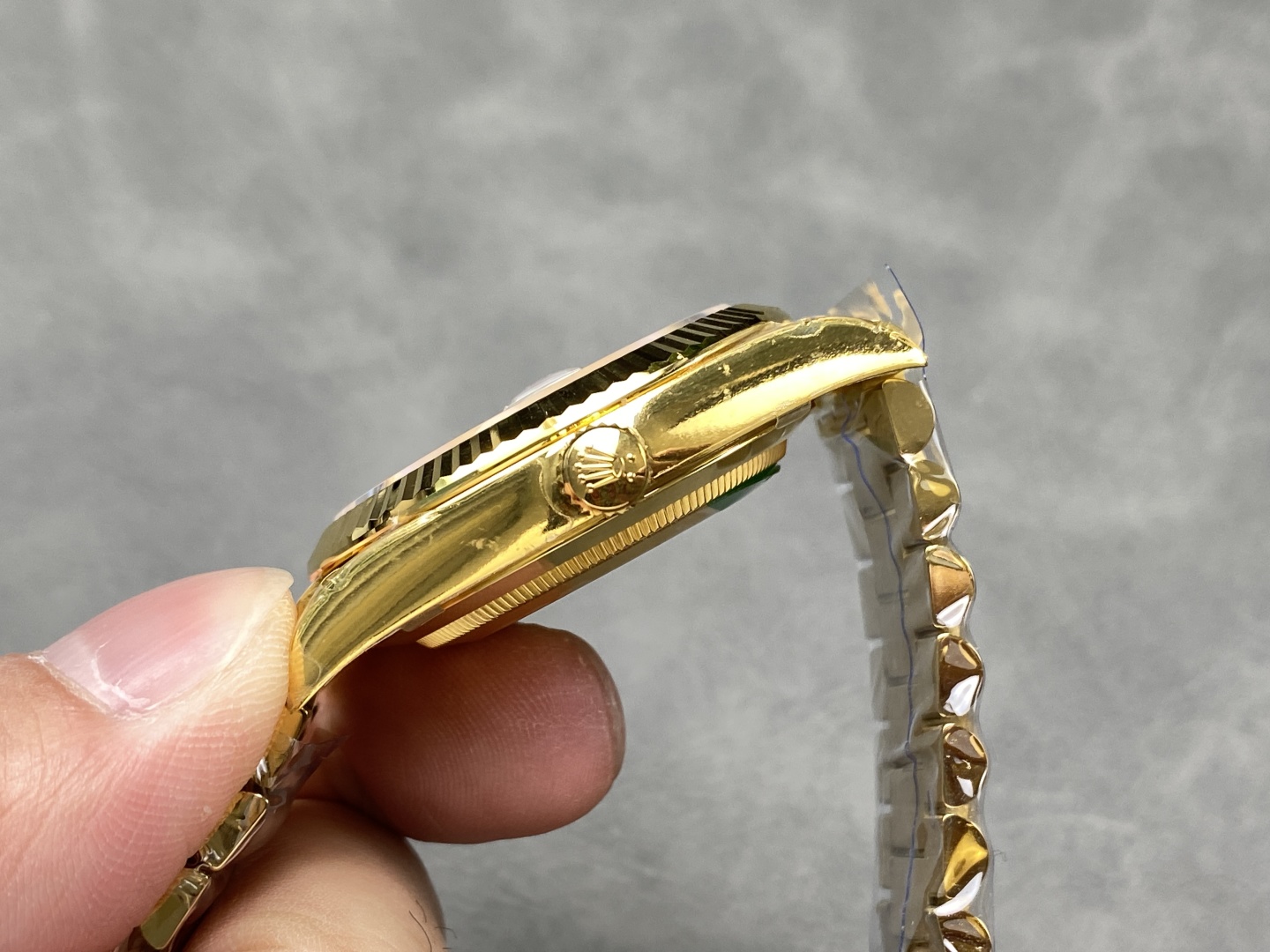 Side profile of gold Rolex Day-Date replica showing fluted bezel crown case thickness and polished lugs