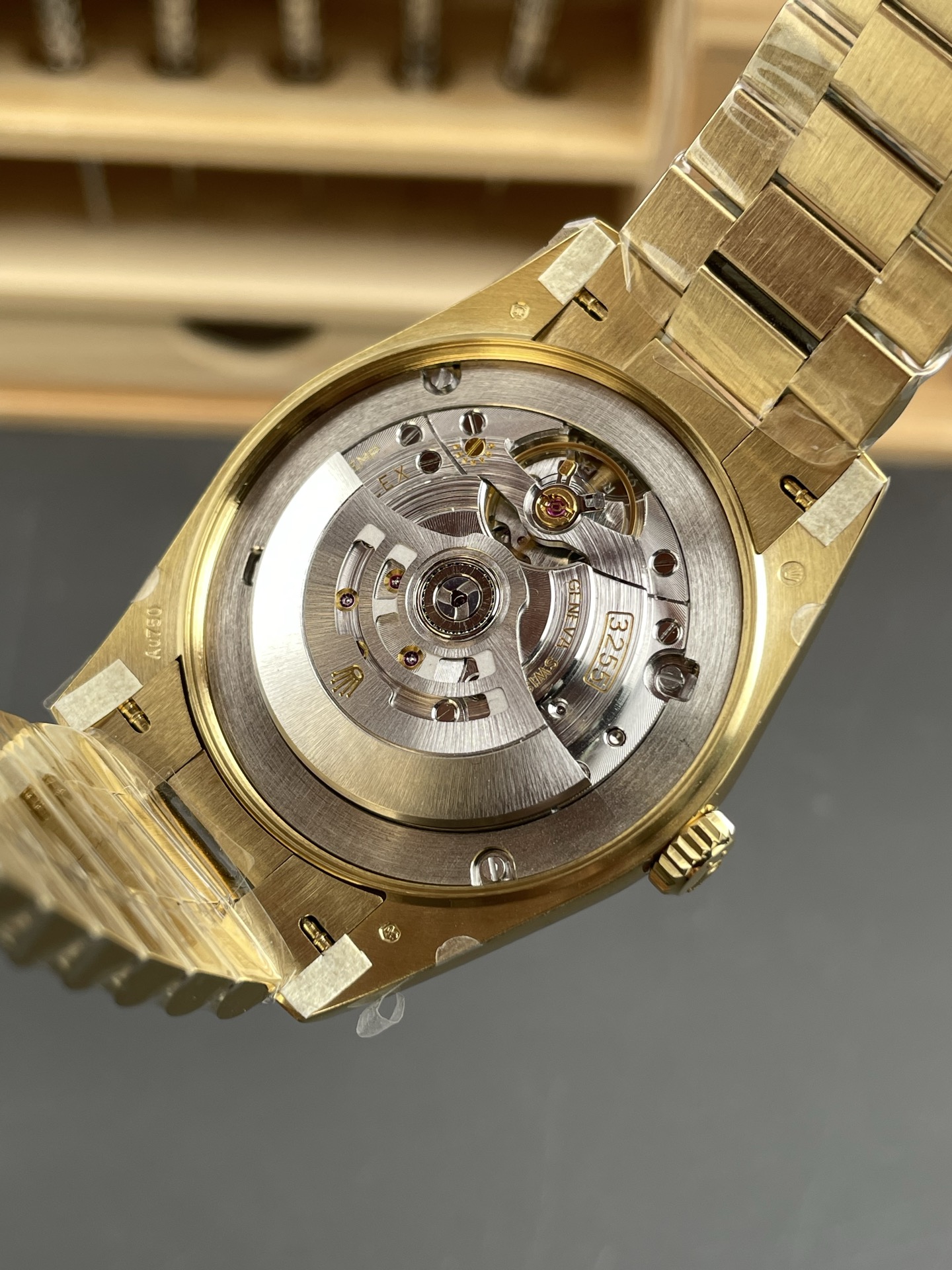 Clone 3255 movement visible through the case back of a gold Day-Date replica watch