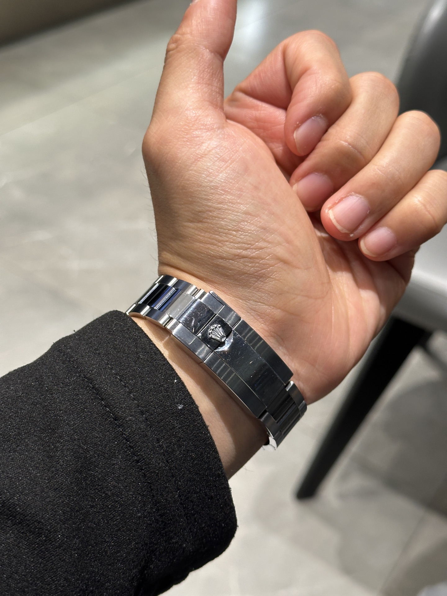 Steel watch bracelet clasp detail photographed on wrist