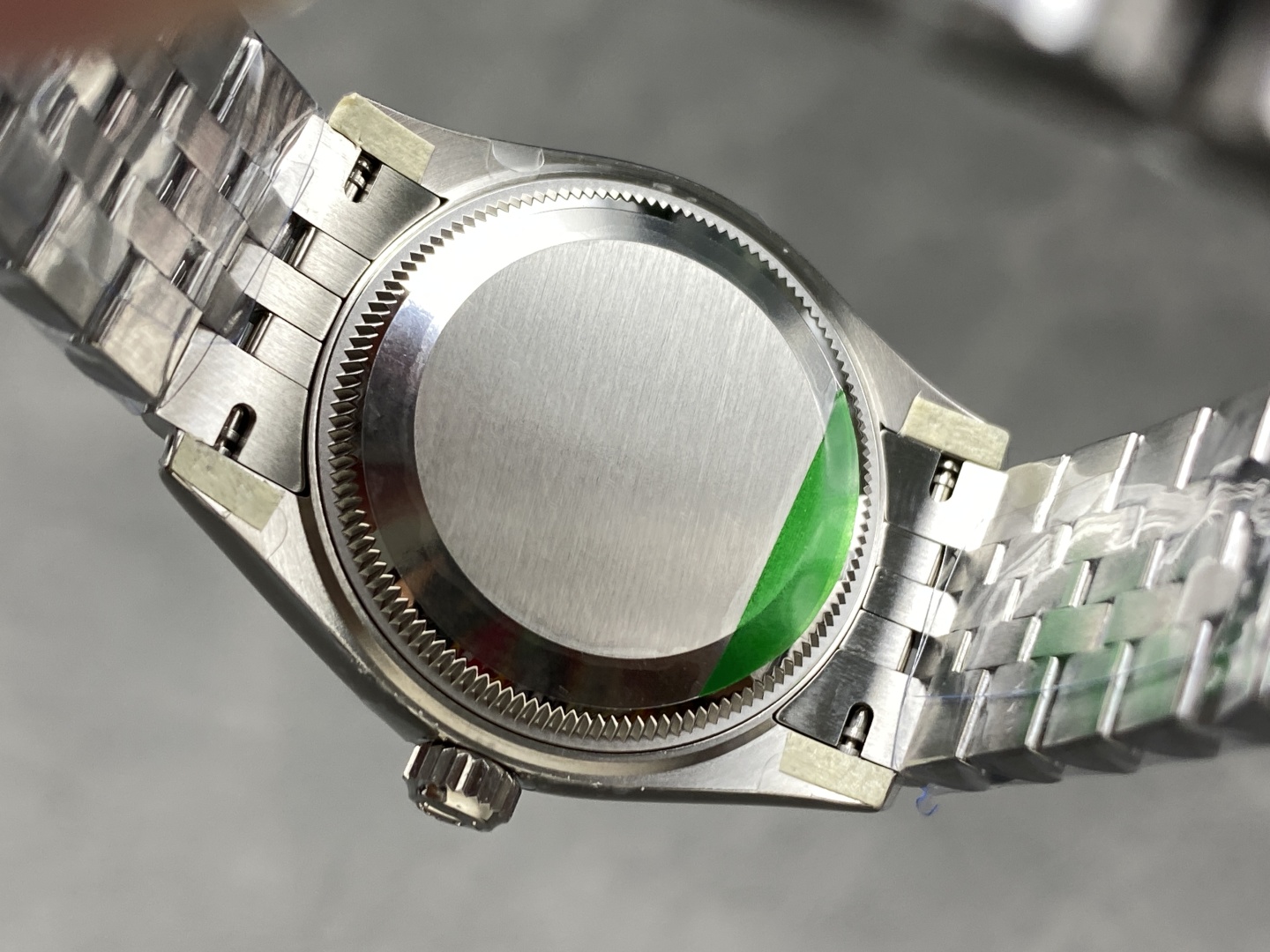 solid caseback with brushed finish and green protective sticker