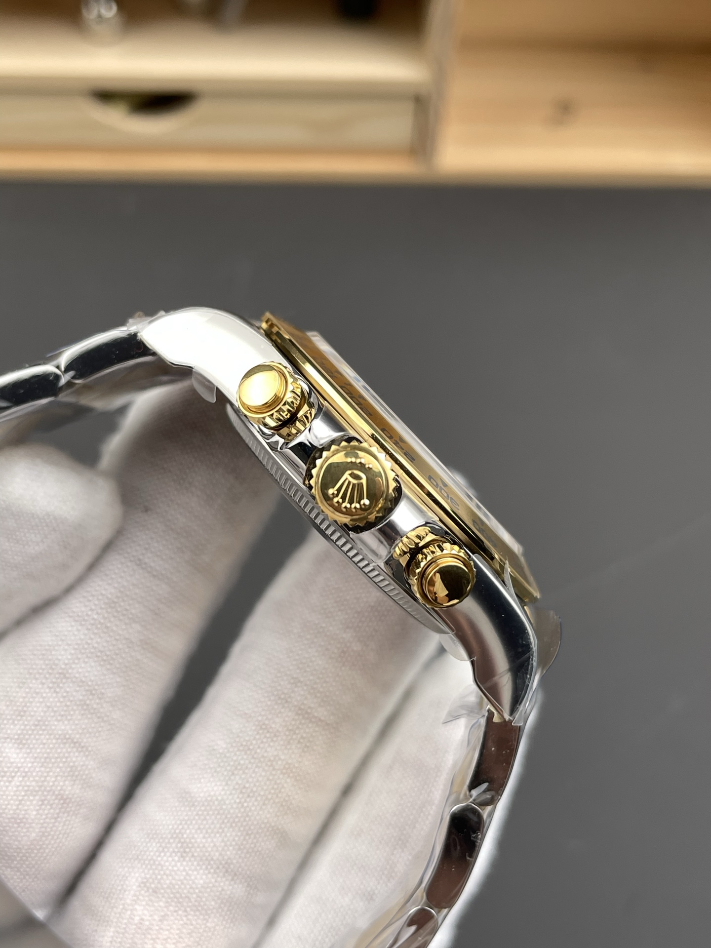 Close-up side profile of luxury replica watch showing the gold crown and chronograph pushers