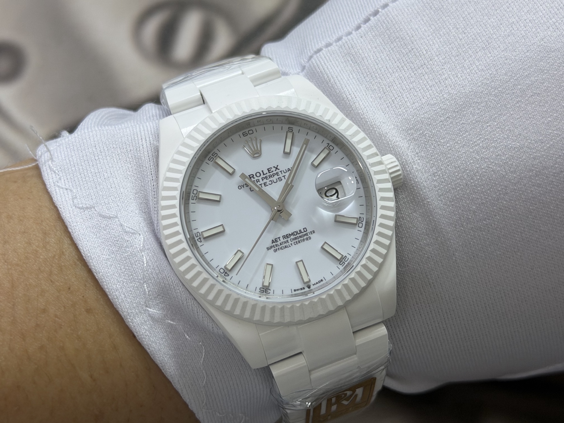 White Rolex Datejust replica with fluted bezel worn on the wrist