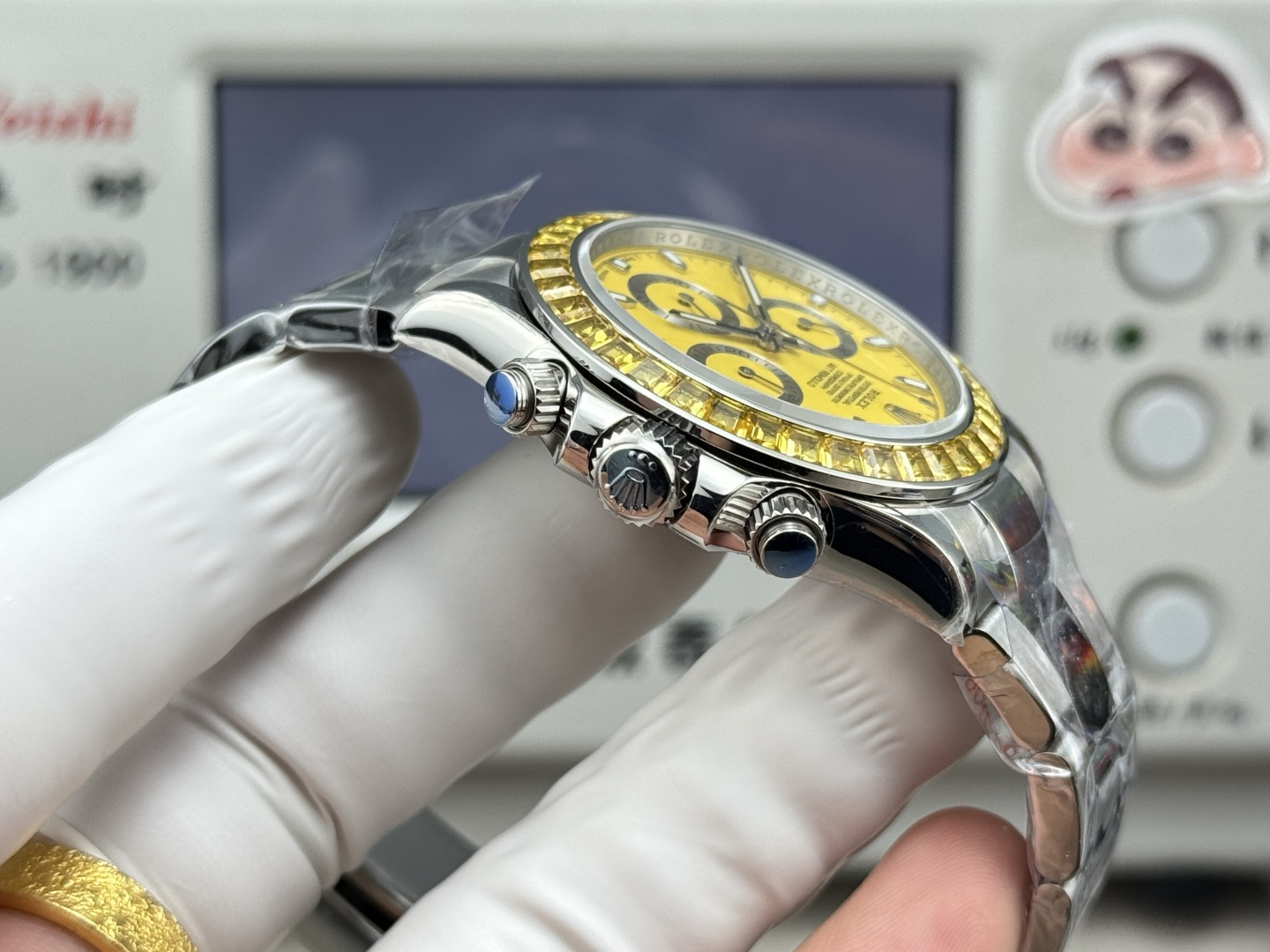 Side angle view of Rolex replica chronograph with blue cabochon pushers and fluted crown demonstrating premium build quality