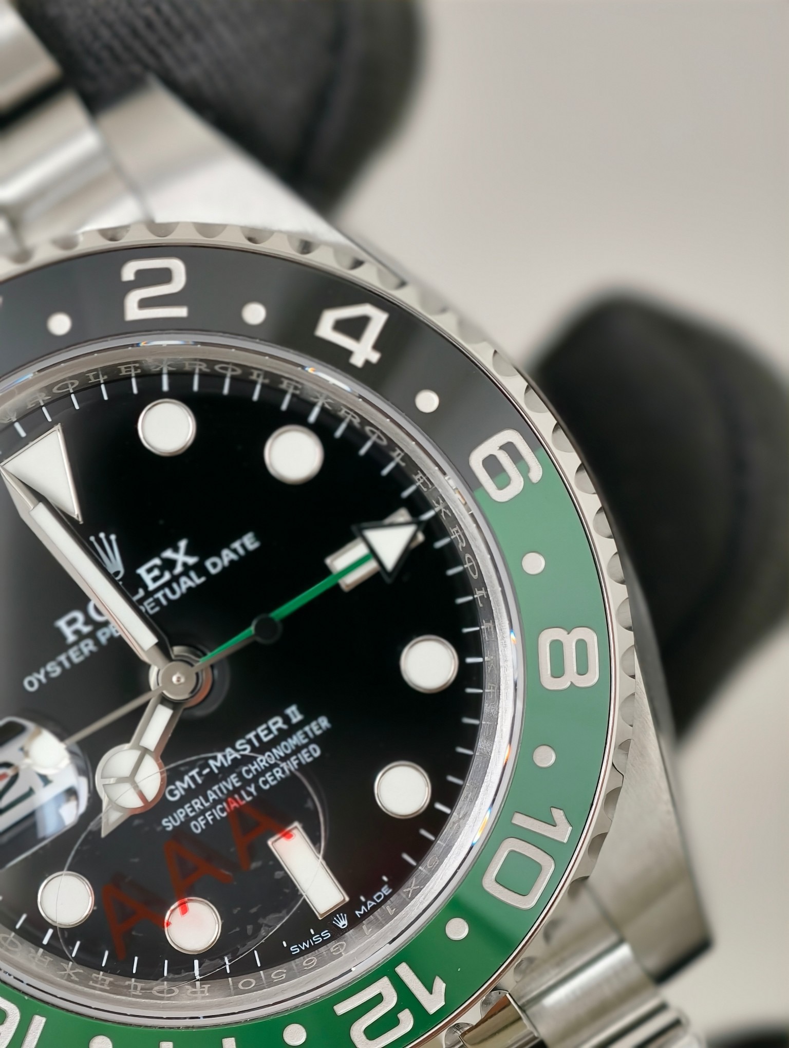 Rolex GMT-Master II replica bezel close-up with black and green ceramic insert and rehaut engraving