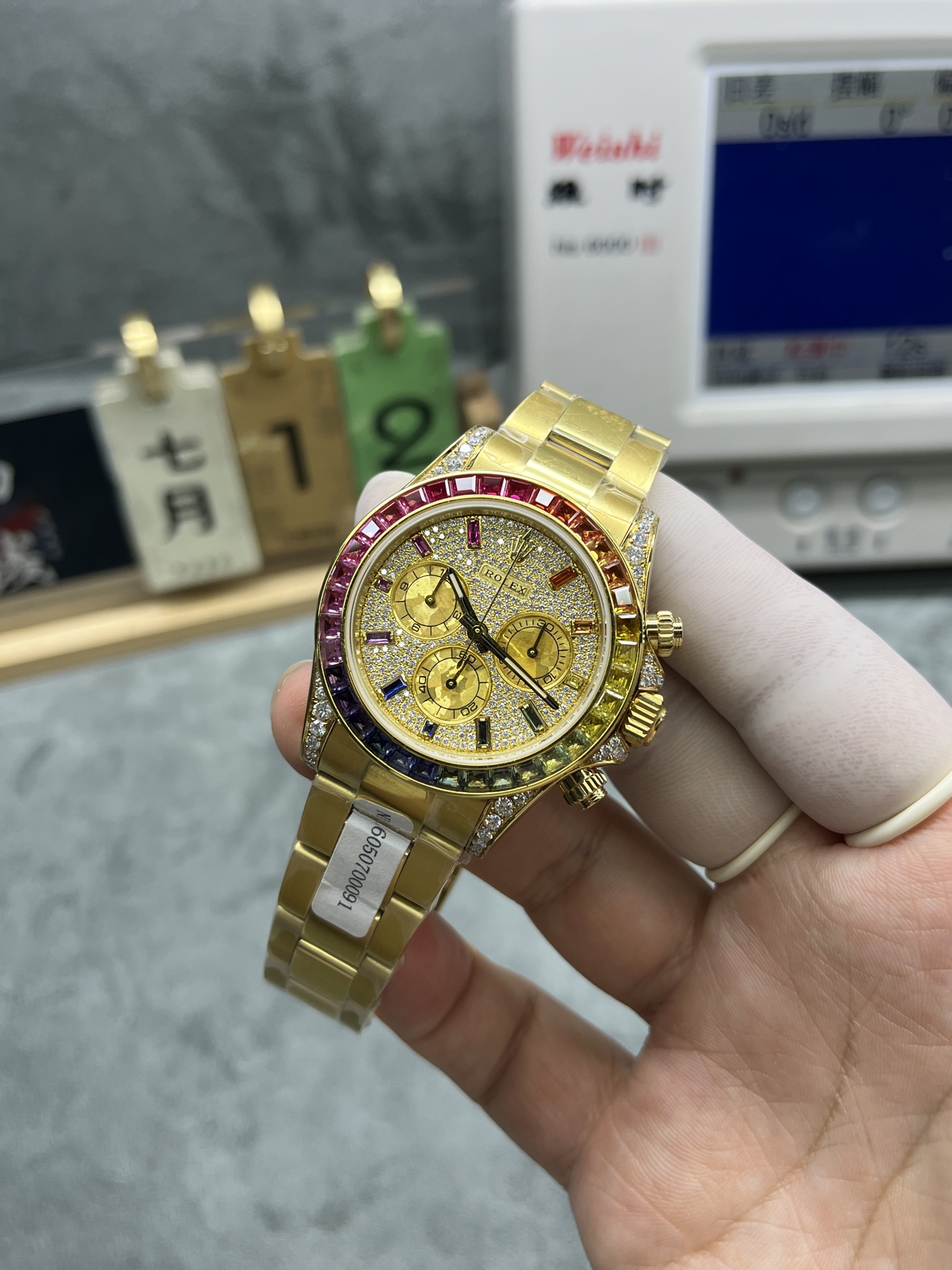front view of rainbow gem-set rolex daytona replica with gold dial
