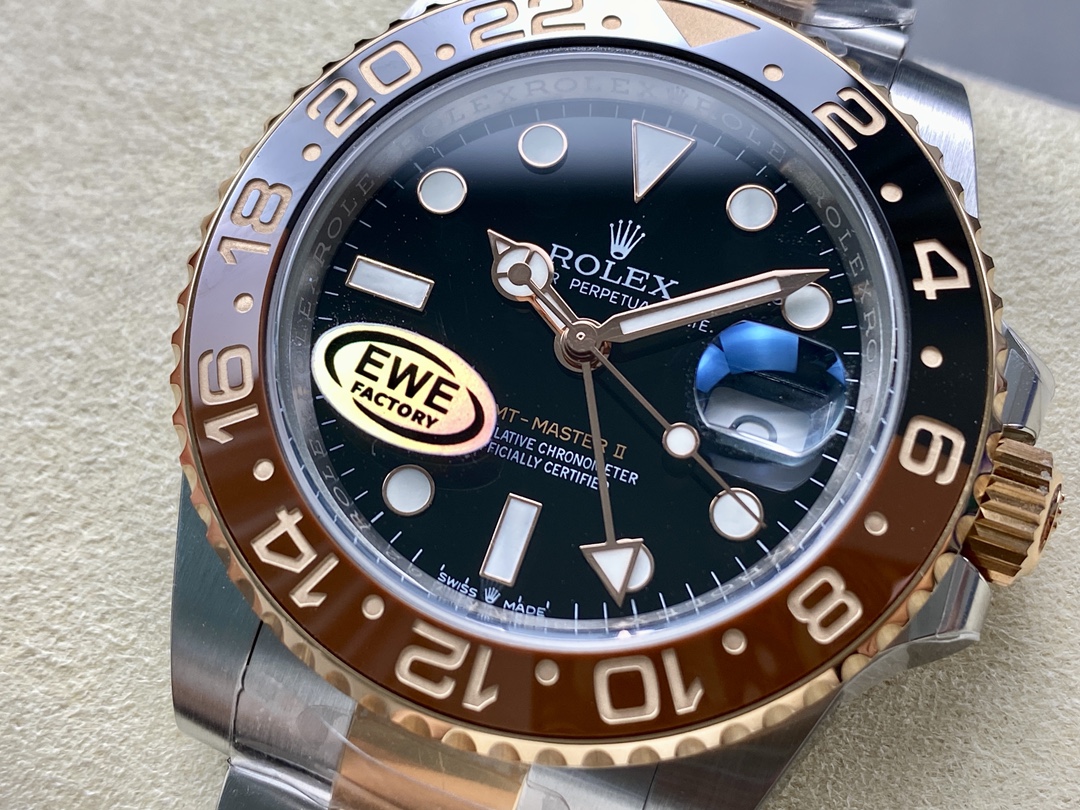 Close-up view of the black dial on a high-quality Rolex replica GMT-Master II showing luminous markers, date window with cyclops, and EWE FACTORY marking