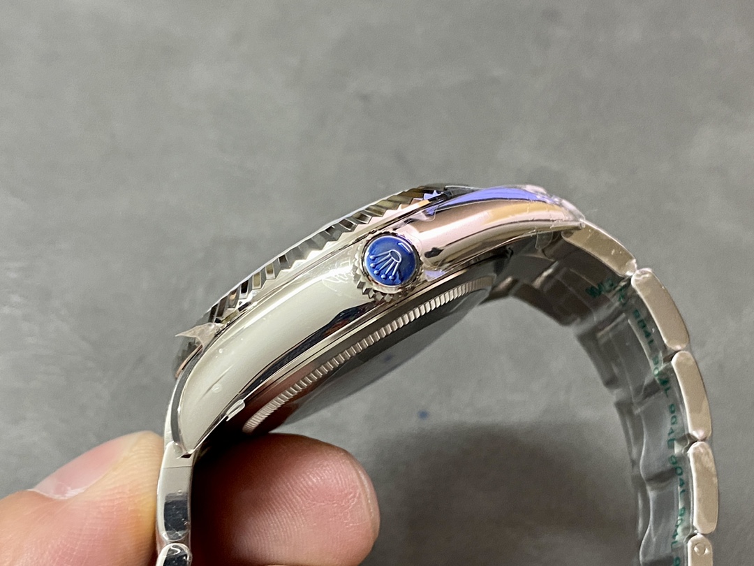 Side profile of a replica Rolex Sky-Dweller featuring the blue crown and fluted bezel