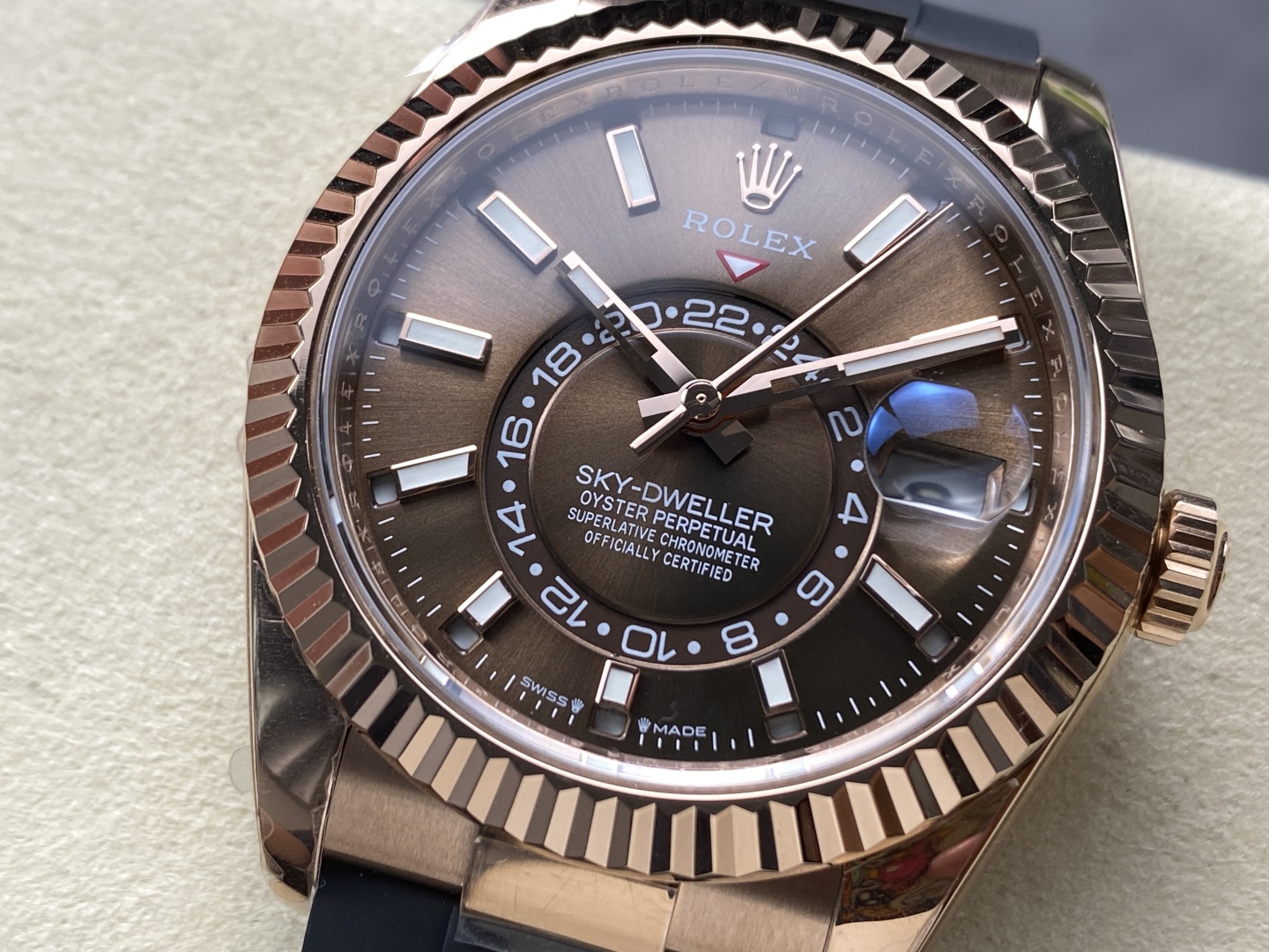 Close-up dial view of a rose gold Rolex Sky-Dweller replica with brown dial and fluted bezel