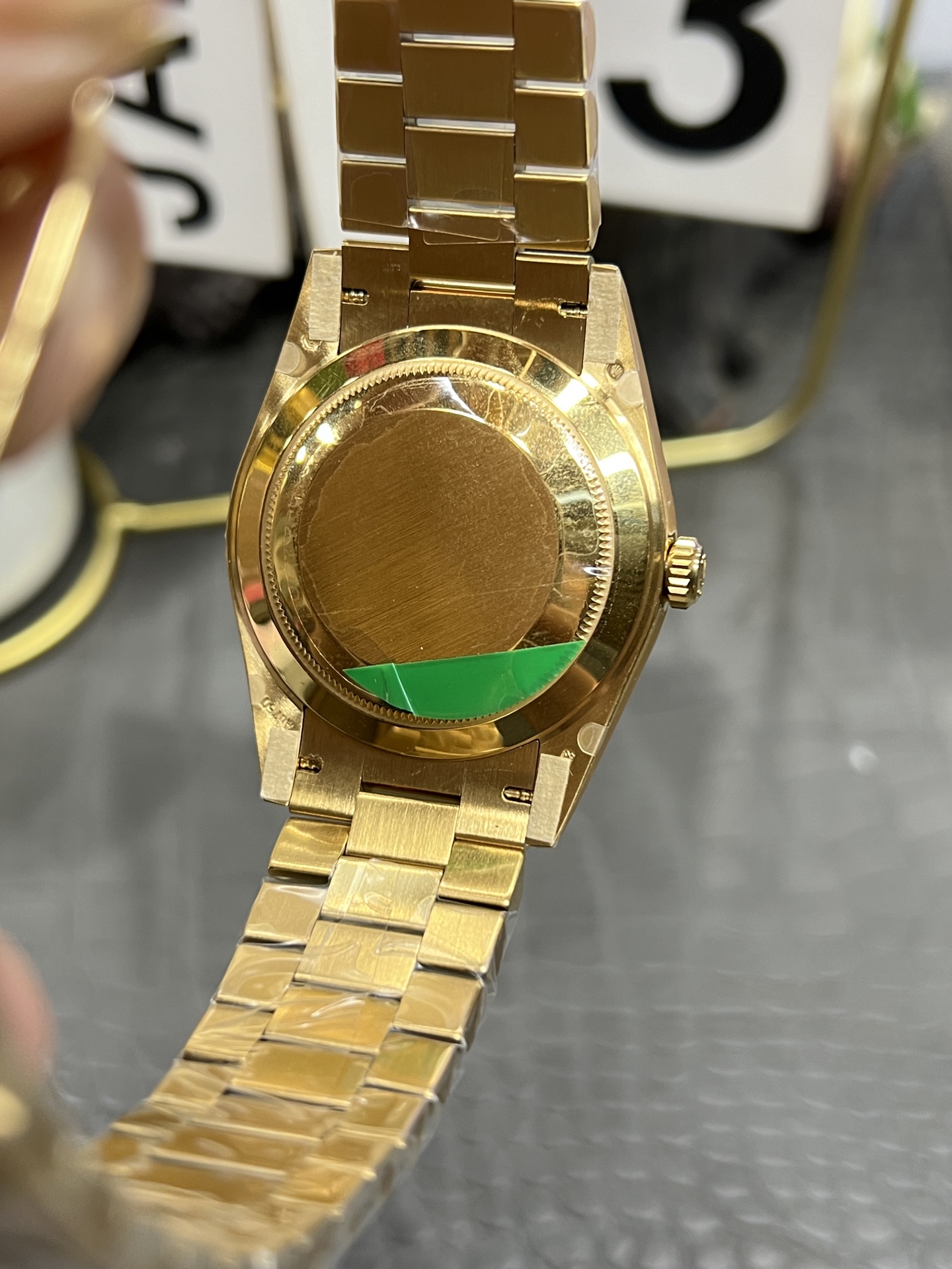Rear view of the gold Rolex replica watch caseback with brushed finish and winding crown