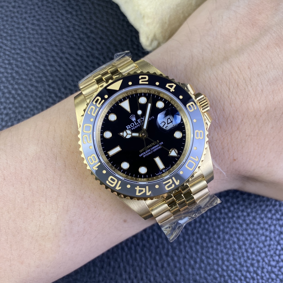 Gold Rolex GMT-Master II replica with black dial and ceramic bezel worn on wrist