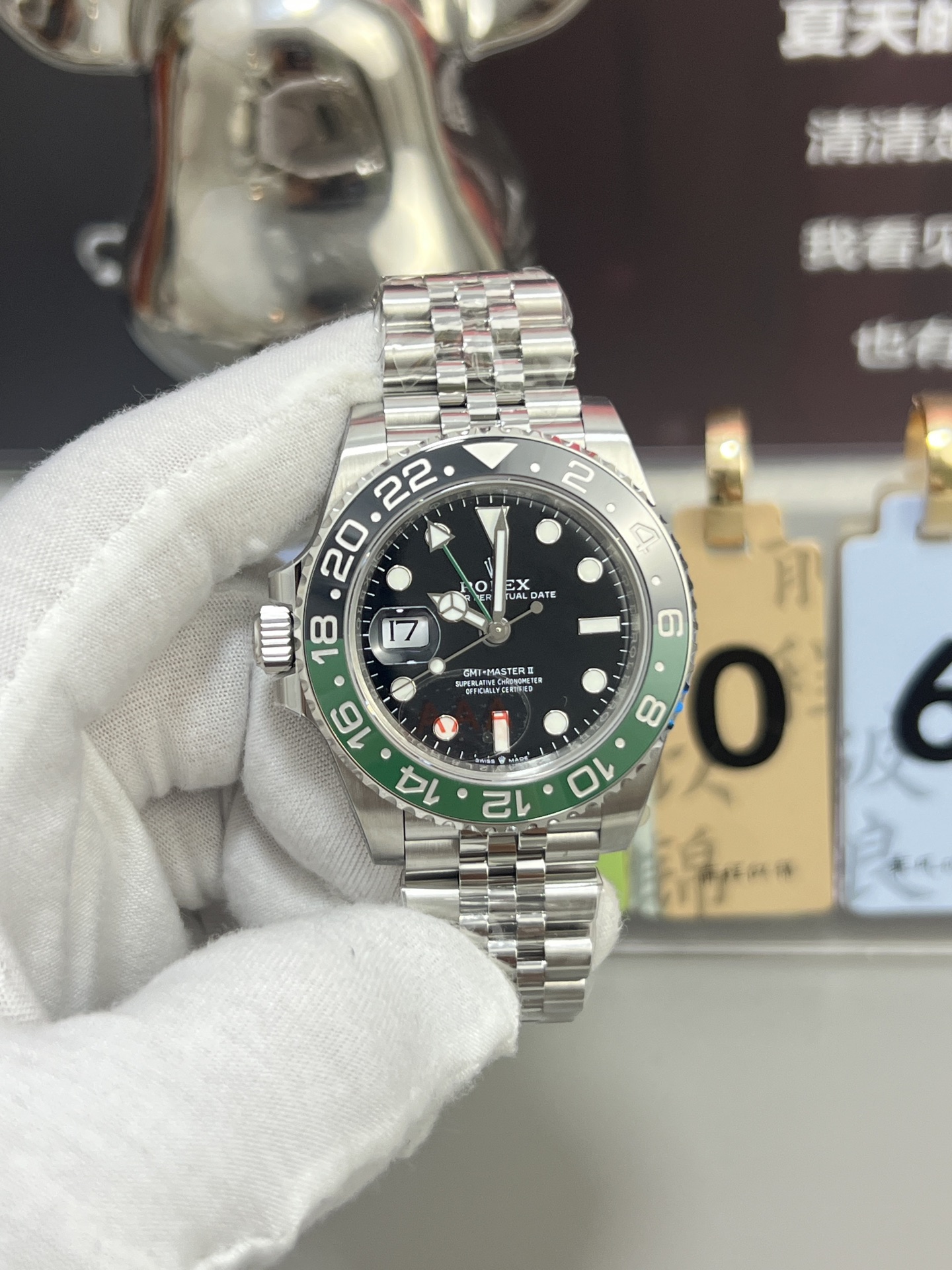 Montre Rolex GMT-Master II avec lunette verte et noire vue de face, bracelet jubilé, tenue par une main gantée