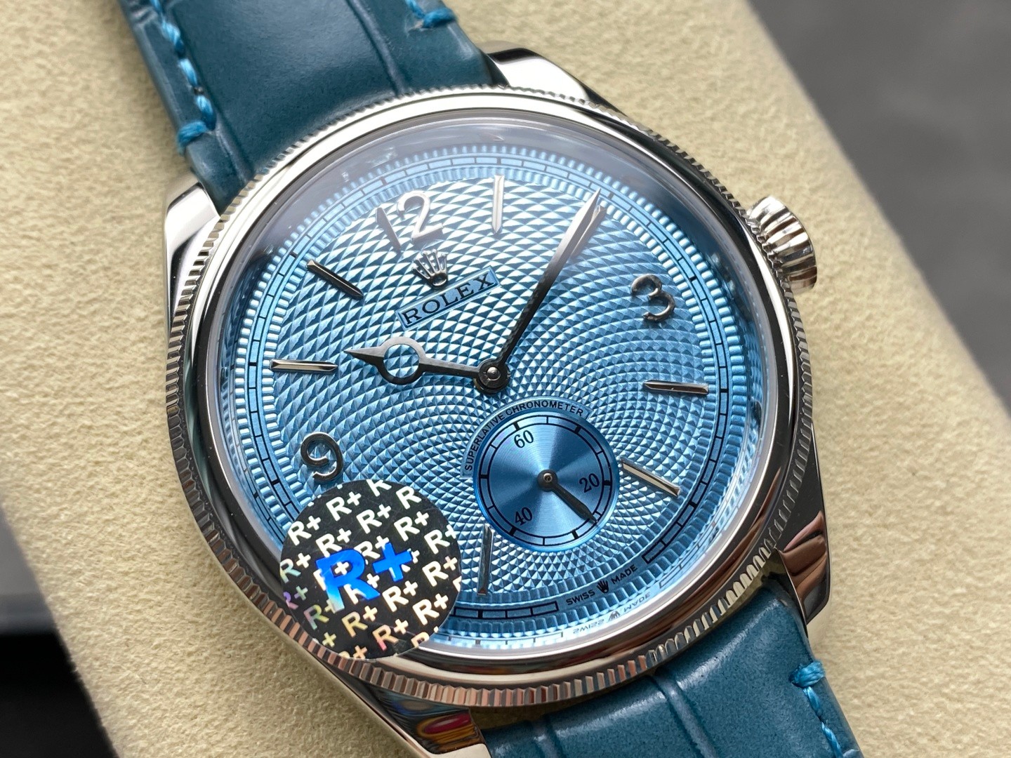 Detail shot of polished steel clasp and textured blue strap on replica watch