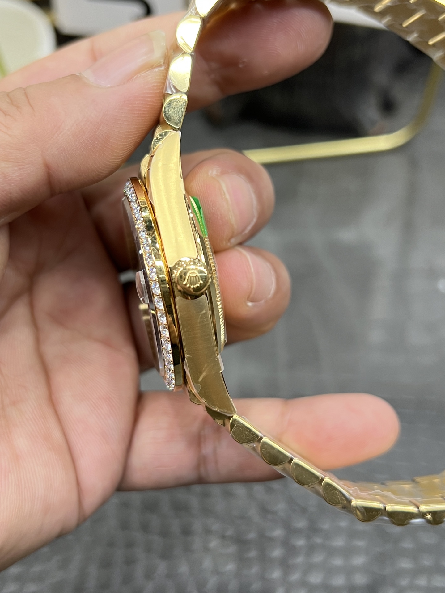 Close-up side profile of gold Rolex replica watch highlighting the fluted crown and sparkling diamond-set bezel