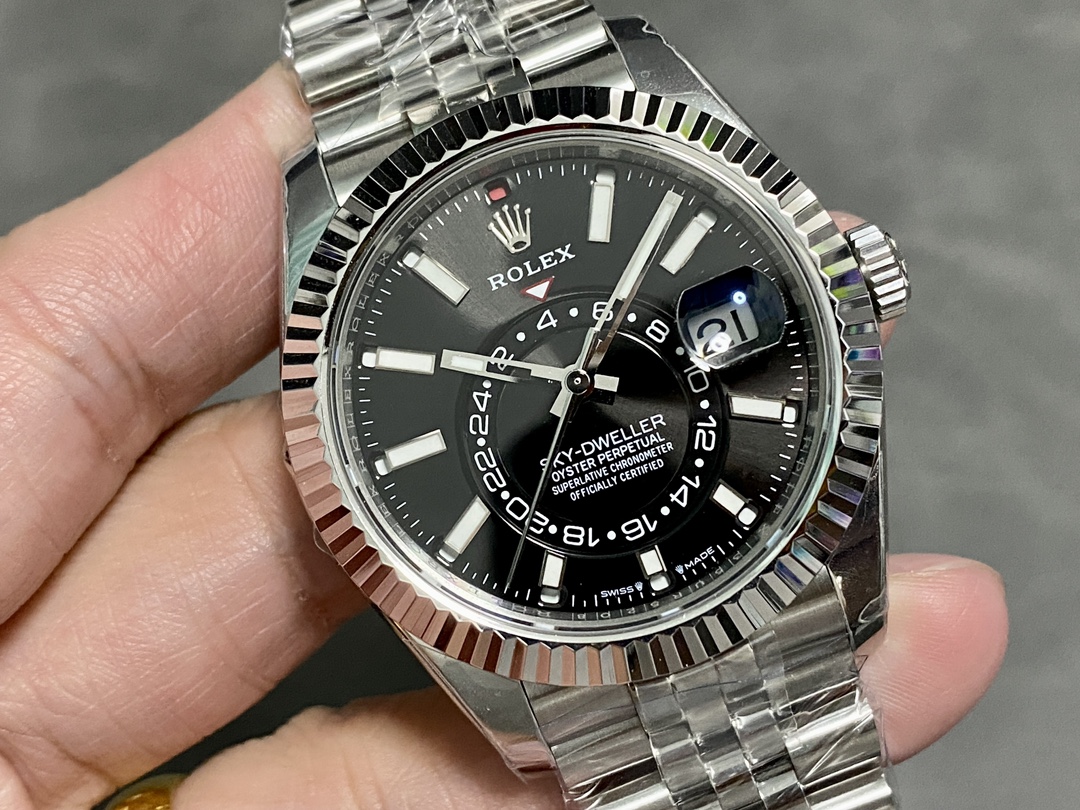 Close-up view of a premium Rolex Sky-Dweller replica with black dial, fluted bezel, and Jubilee-style bracelet on a wrist