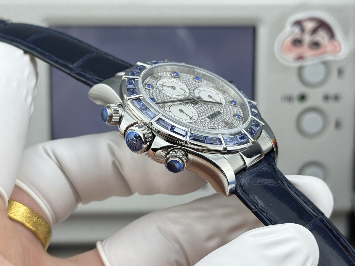 Side profile of Rolex Daytona replica showing polished case chronograph pushers blue crown accents and blue leather strap