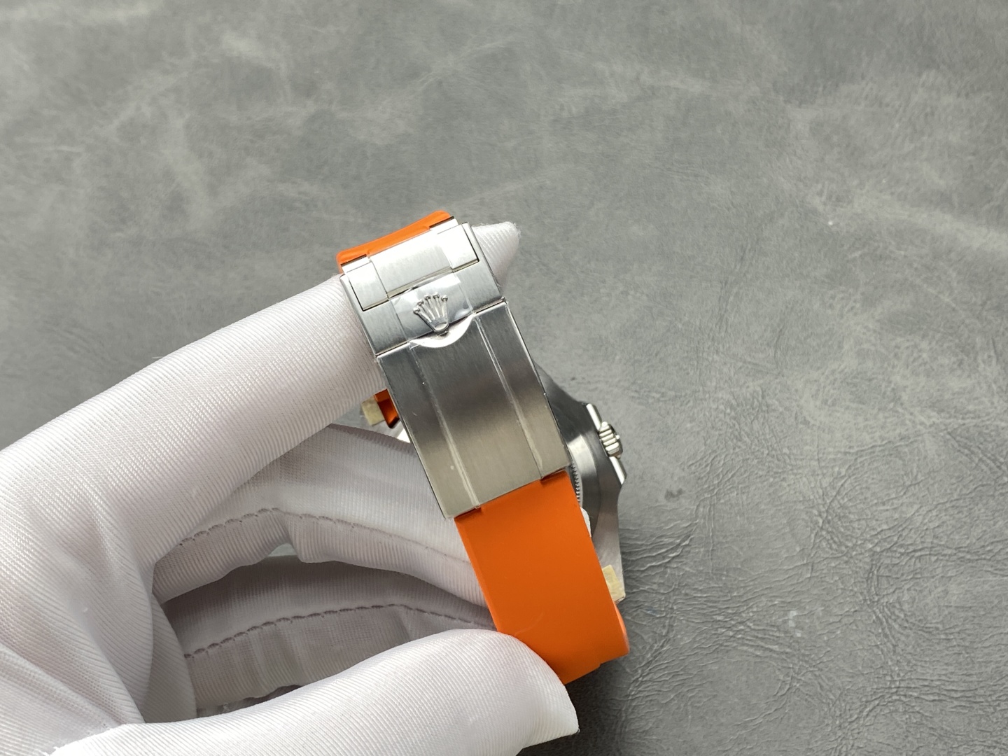 Close-up of the deployant clasp on Rolex Explorer II replica with crown logo and orange strap