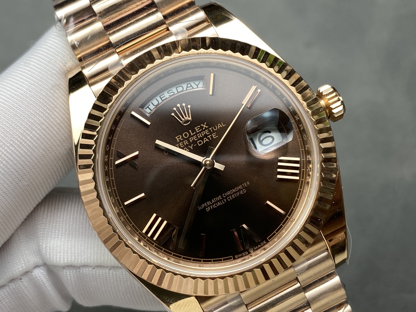 Close-up rose gold Rolex Day-Date replica watch with brown dial and fluted bezel