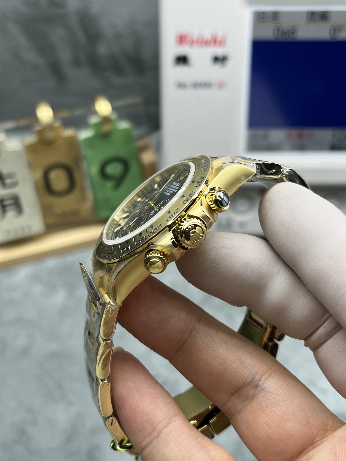 Side profile of gold Daytona replica showing pushers and crown