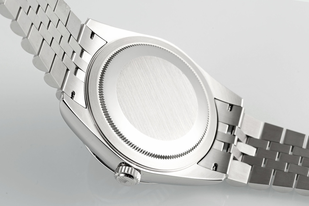 Detailed close-up of Rolex screw-down caseback with brushed concentric circular lines, knurled edge, and attached Jubilee bracelet links on white background
