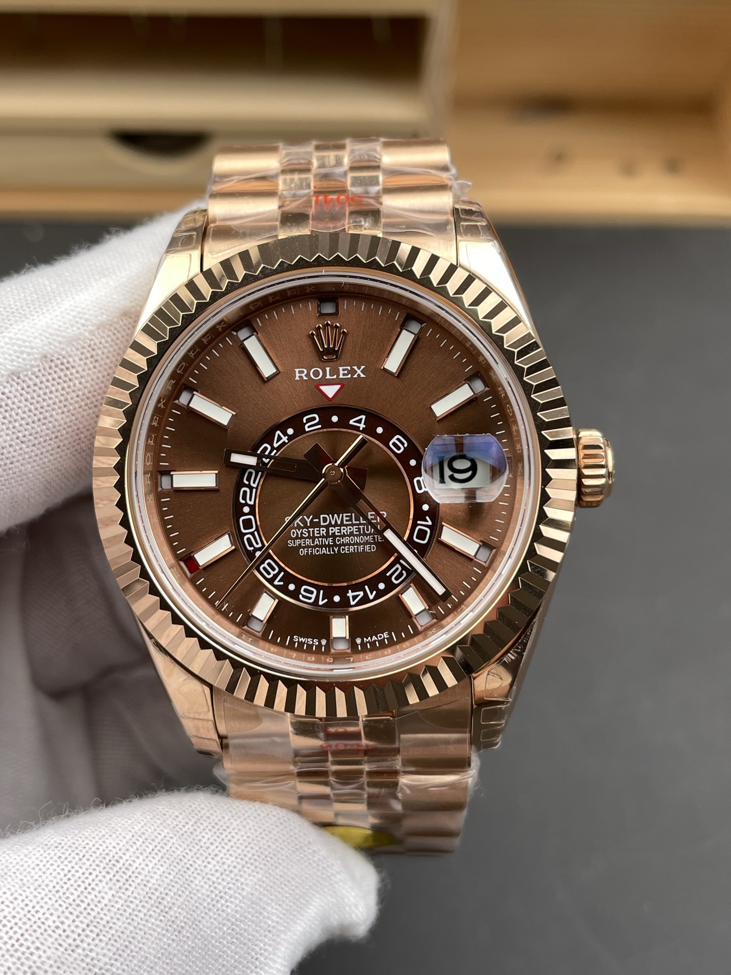 Rose gold Rolex Sky-Dweller replica watch dial with fluted bezel and brown face