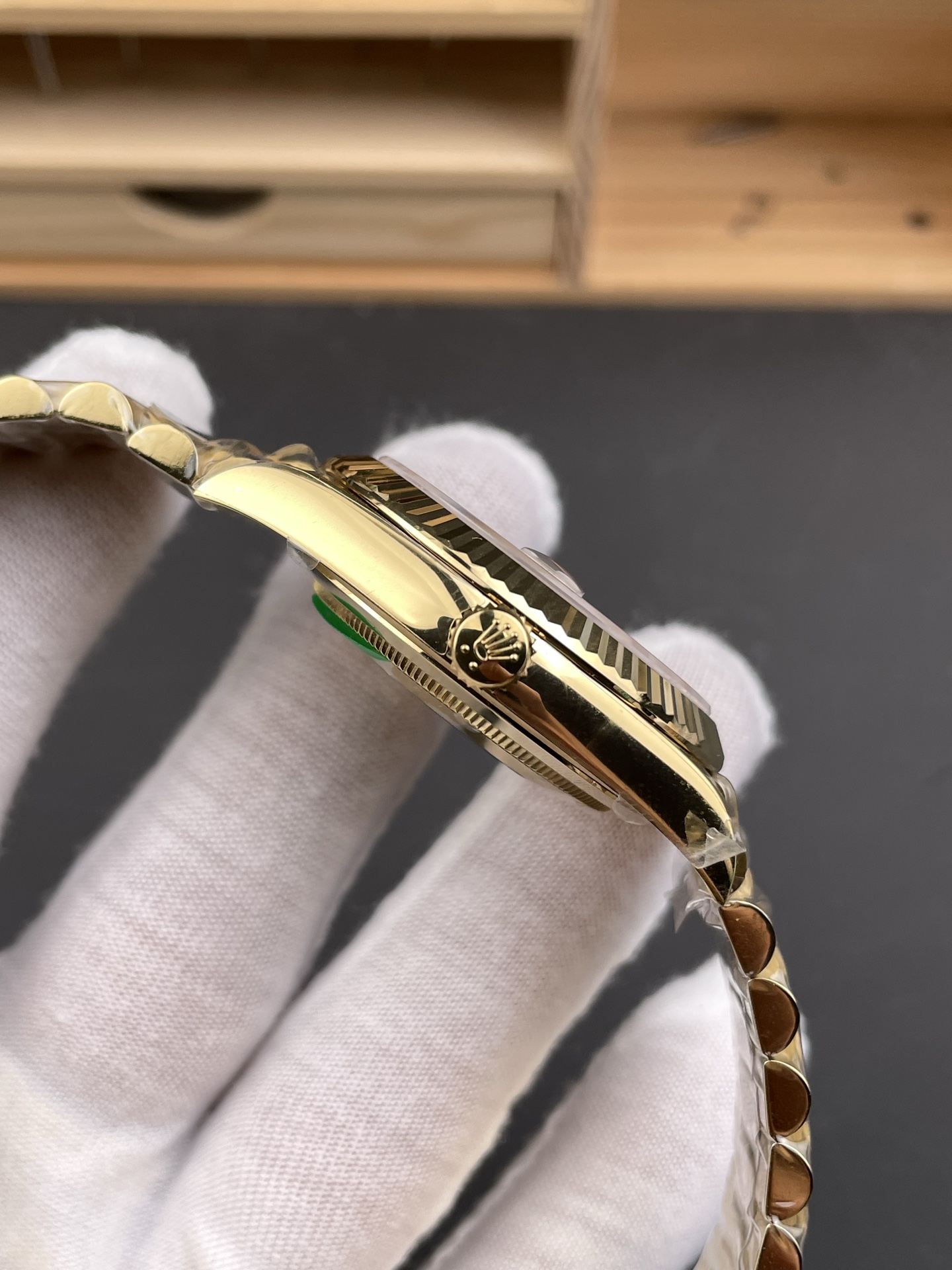 Side profile of a gold Rolex Day-Date replica showing case thickness, crown, and fluted bezel