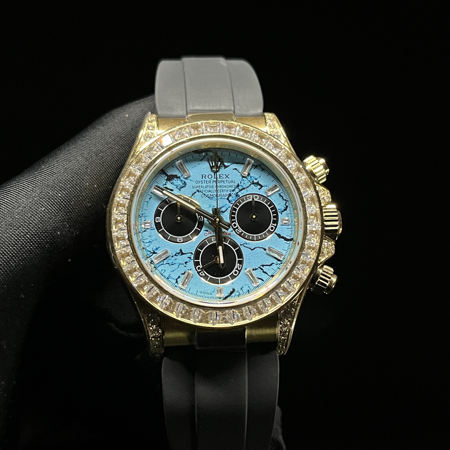 High-end Rolex Daytona super clone with full baguette-cut diamond bezel, light blue marbled dial, and gold case on Oysterflex strap