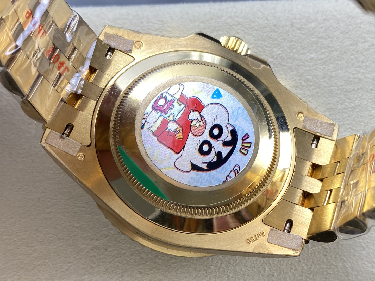 Gold Rolex clone watch caseback with bracelet links and protective stickers