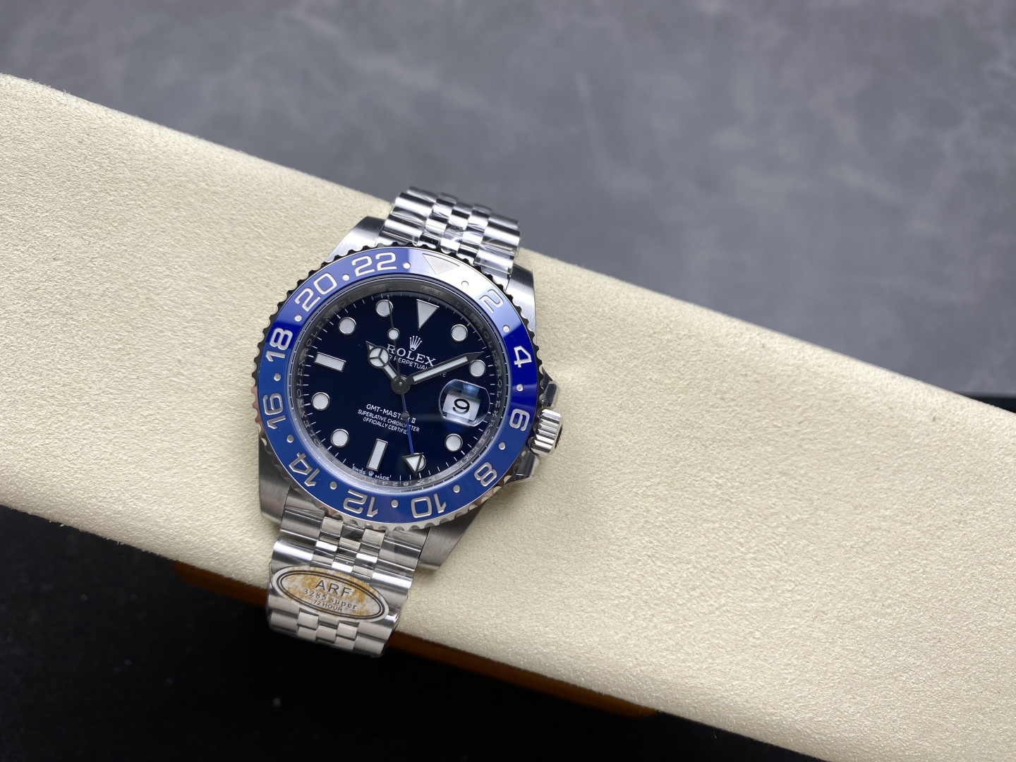 Hochwertige Rolex GMT-Master II Replik mit 3285 Maschine auf cremefarbenem Displaykissen - Nahaufnahme von Zifferblatt, Zeigern und zweifarbiger Keramiklünette