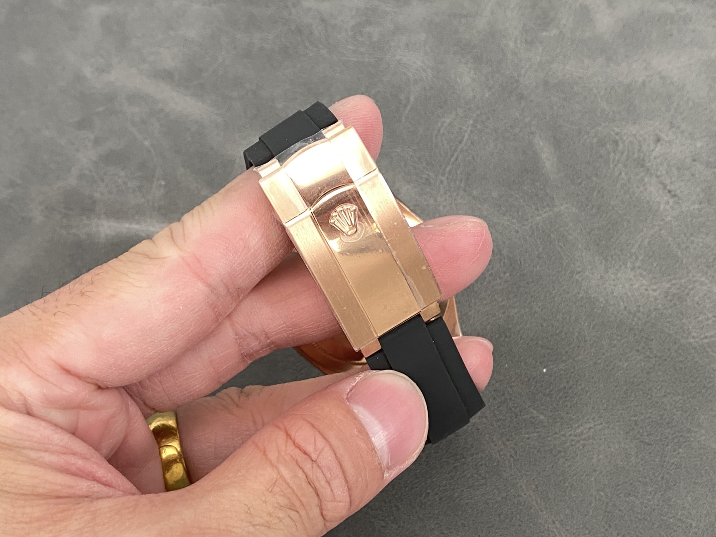 Detailed view of the rose gold clasp and black rubber strap on the Rolex Sky-Dweller replica