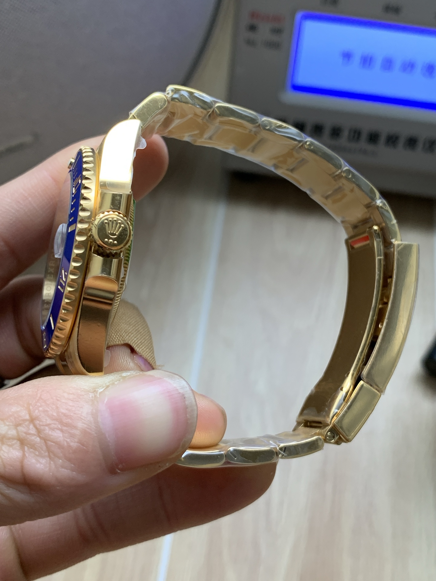 Detail der Faltschließe mit Rolex Krone Logo und goldfarbenem Armband einer hochwertigen Replika