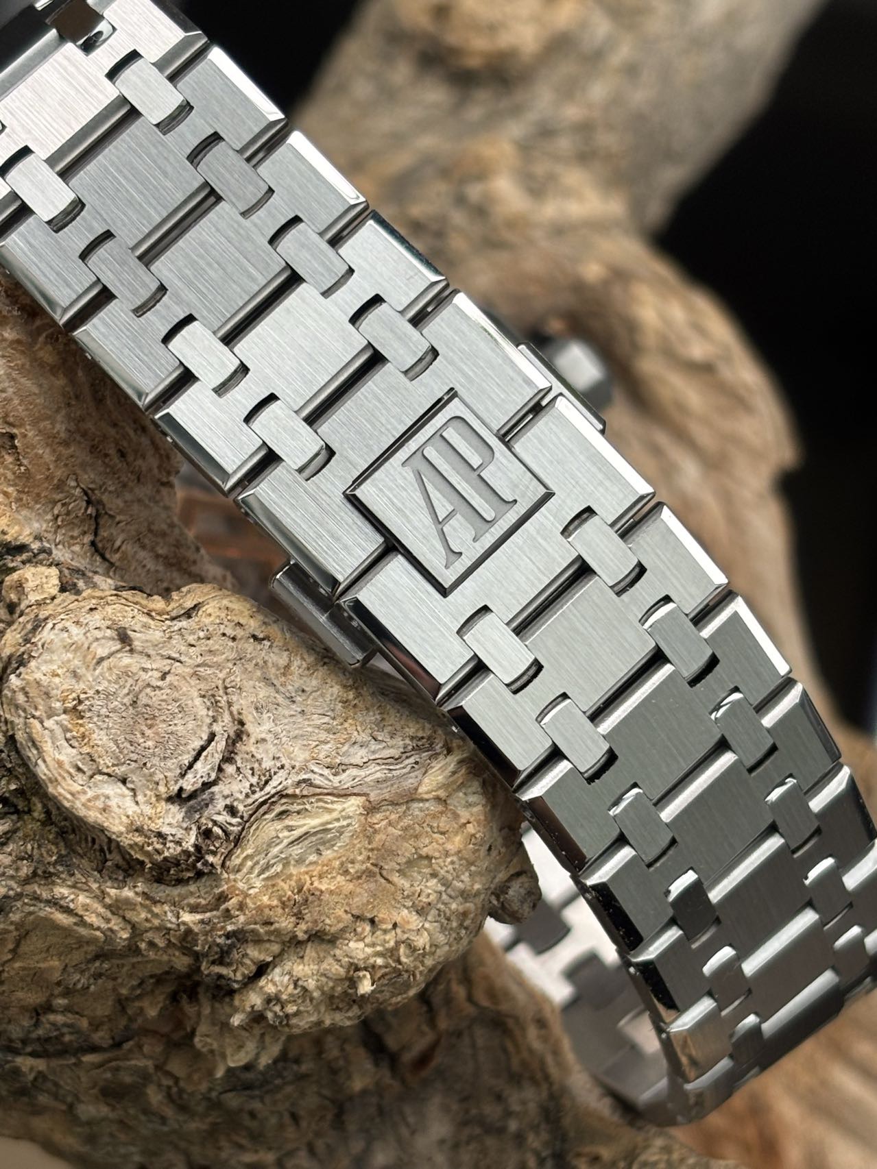 Brushed integrated Royal Oak bracelet with AP clasp detail on wood background
