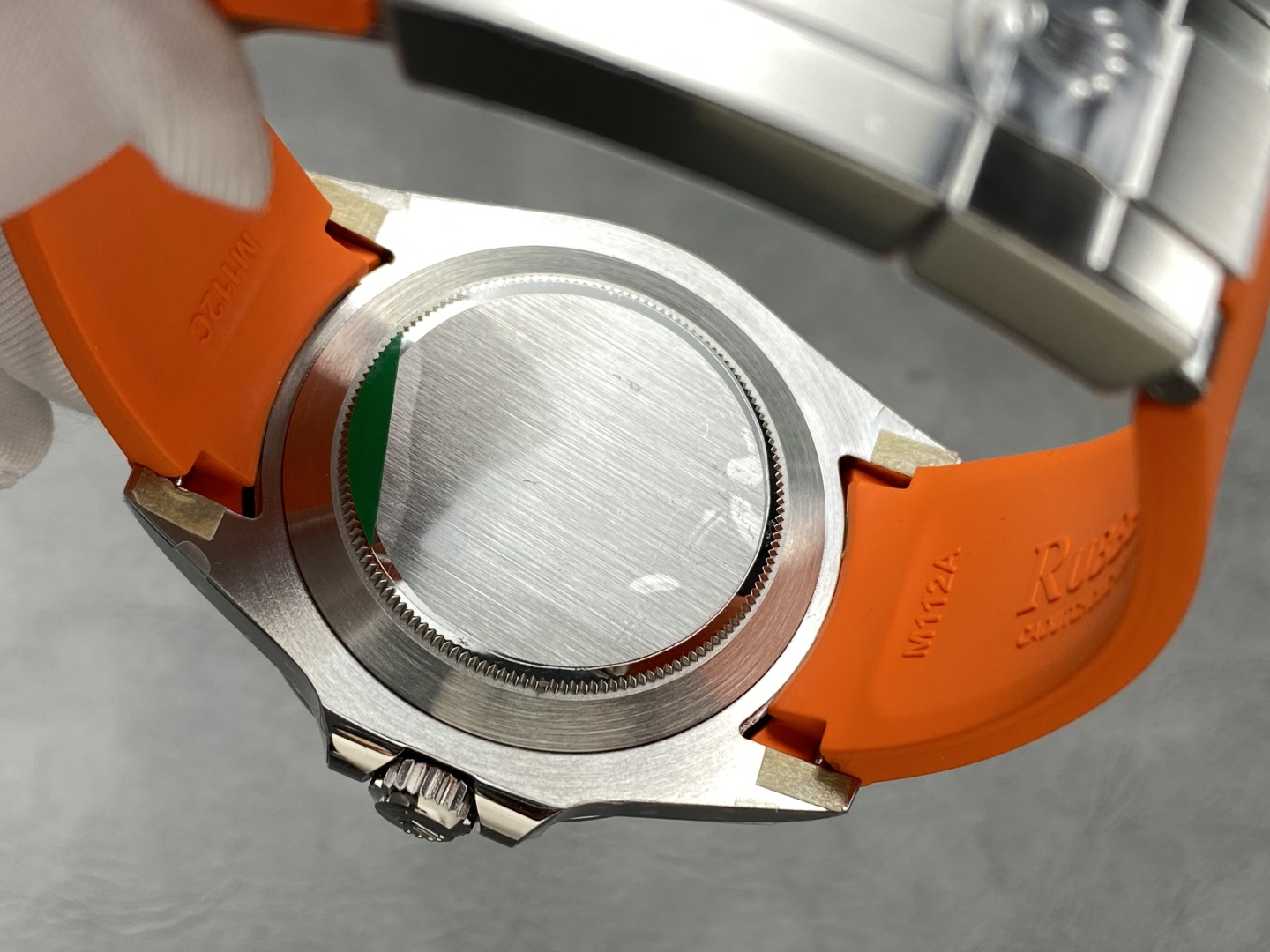 Detailed view of the caseback on a Rolex Explorer II replica with brushed finish and orange rubber strap markings
