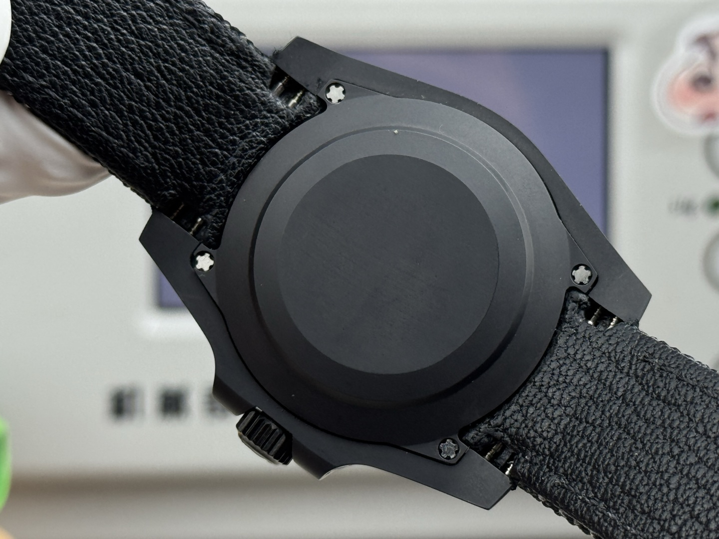 Replica Rolex Submariner case back with DLC coating and four screws, showing the solid black finish.