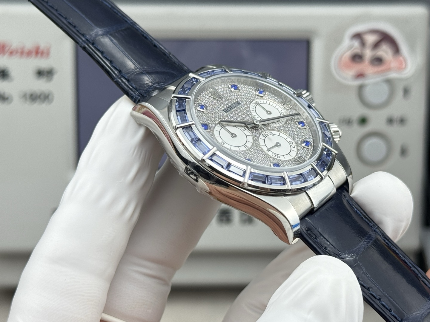 Angled Rolex Daytona replica with blue baguette bezel and diamond style dial on blue leather strap