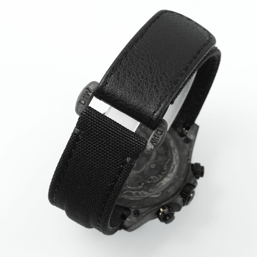 Back view of black wristwatch with dual-material strap, carbon fiber case, and engraved caseback details