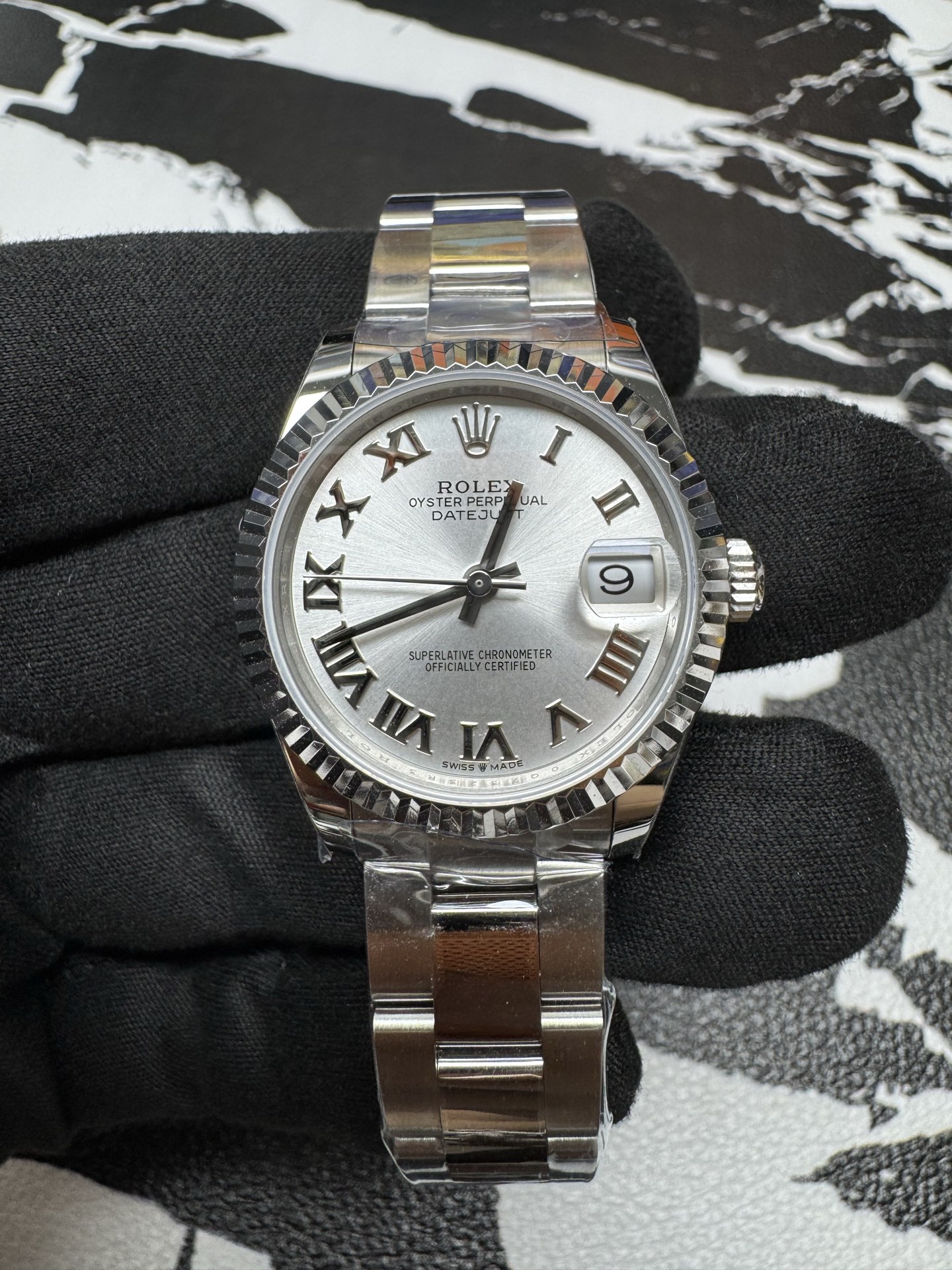 Close-up of the silver dial with roman numerals and date cyclops on a fake Rolex Datejust 36.