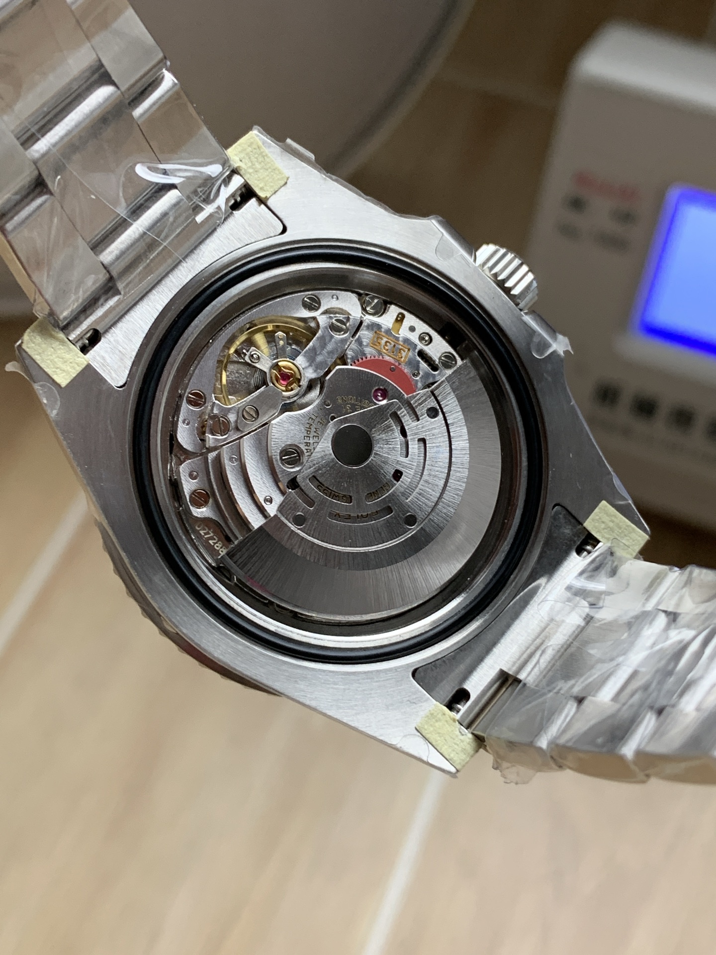 Open caseback showing 3135 style clone automatic movement inside a replica Rolex