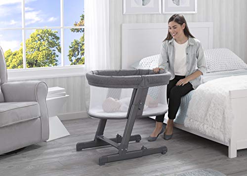 Delta Children Simmons Kids Oval City Sleeper Bedside Bassinet - Adjustable Height Portable Crib with Wheels &a; Airflow Mesh, Grey Tweed