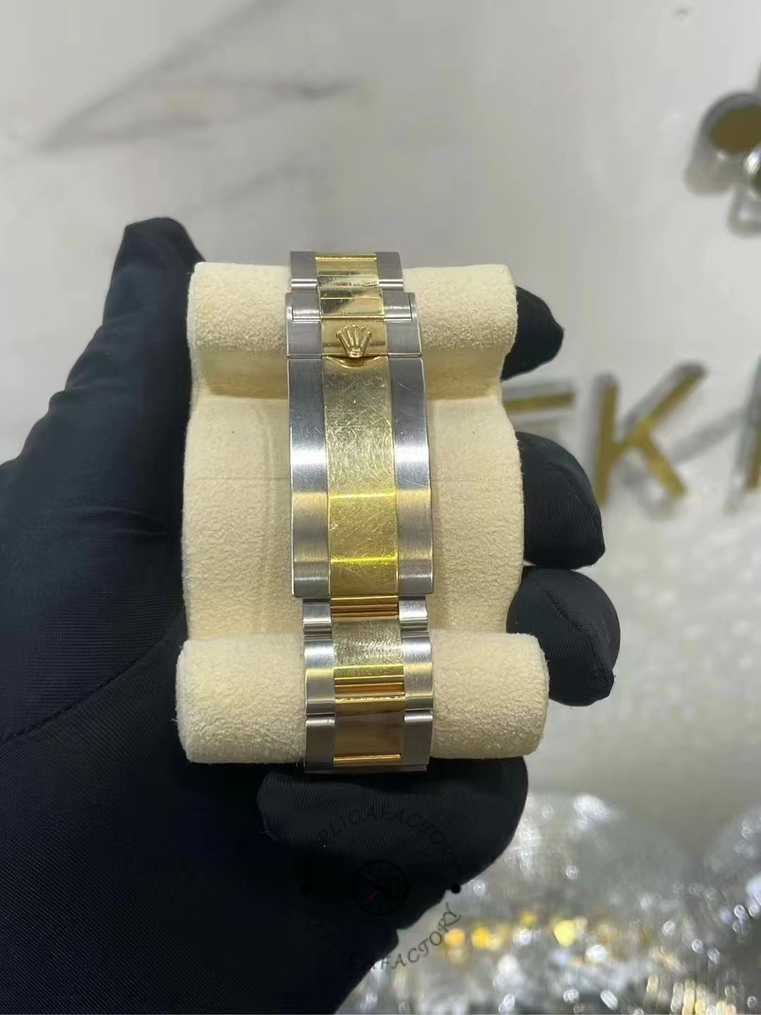 Rear view of bracelet of a used Rolex Submariner 126613LN-0002, showing gold center links and Rolex clasp.