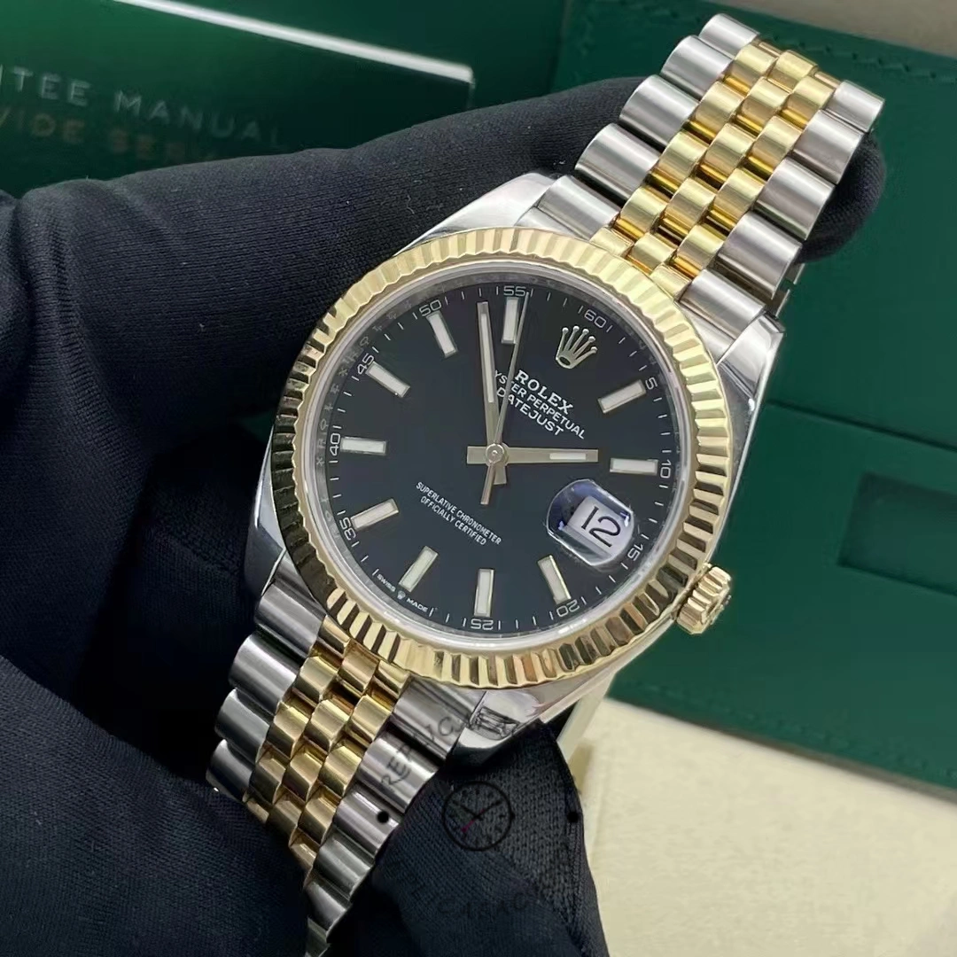 Close-up, hand-held view of the Rolex Datejust 41 126333 with fluted bezel and date magnifying glass.